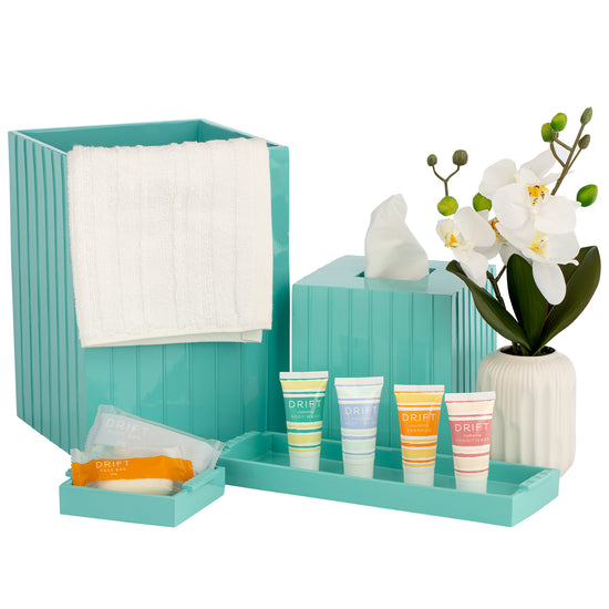 Turquoise | Minimalist bath accessories collection set in a vibrant color scheme, complementing a contemporary guestroom or spa setting.